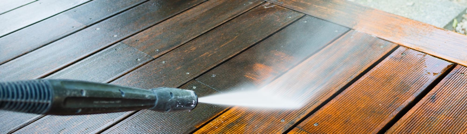 Pressure washer cleaning grime off wood deck